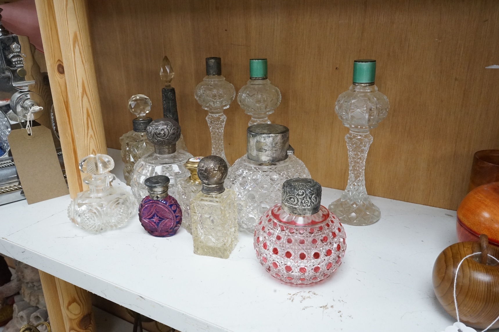 A collection of ten cut glass scent bottles, some with silver and enamel mounts, largest 20cm high
